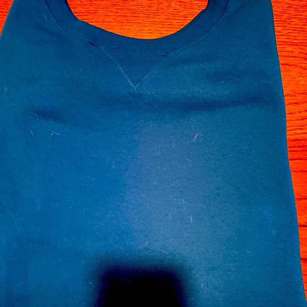 Woman within brand new long 3/4 sleeves sweatshirt. The color is a vibrant blue.